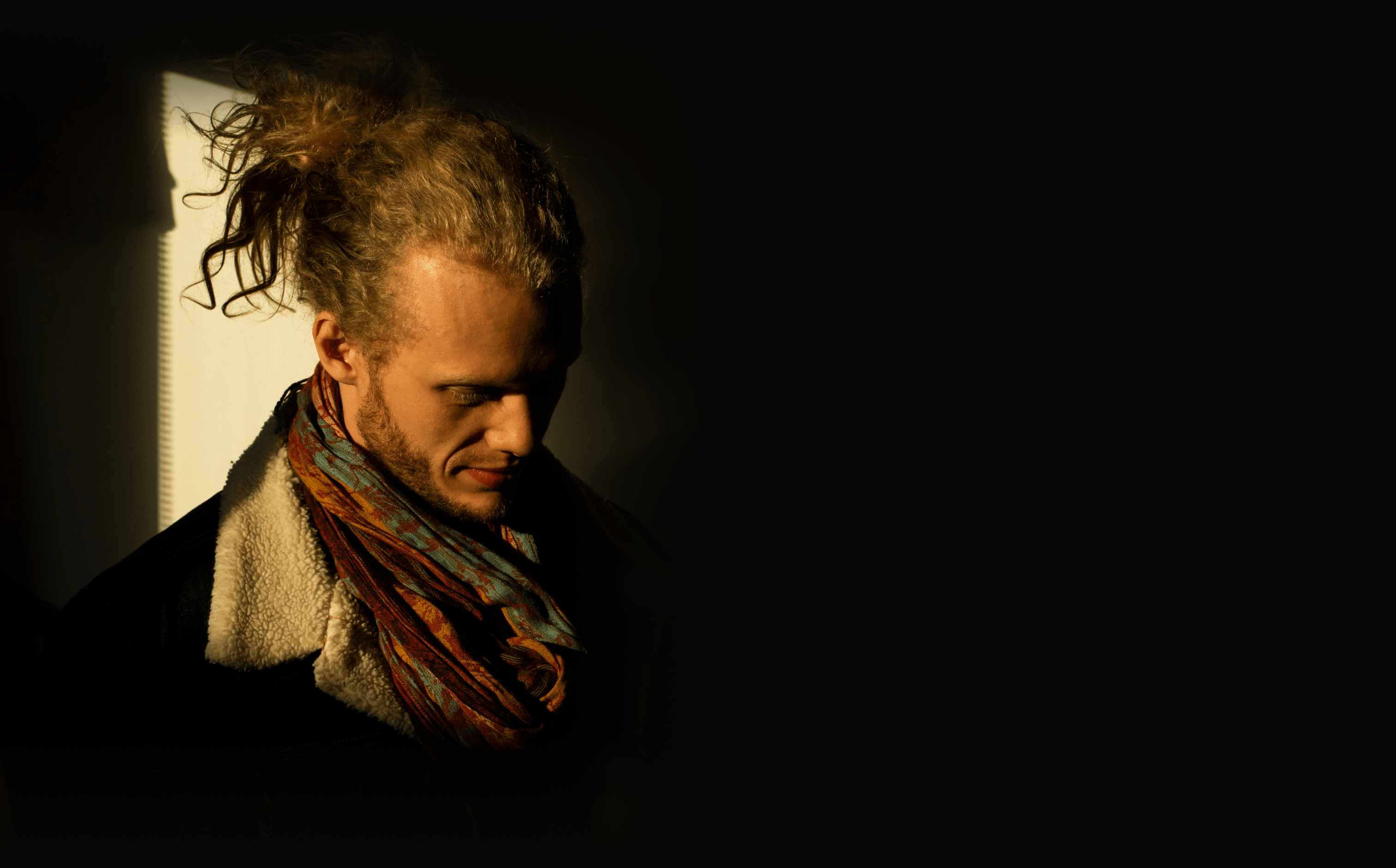 Joshua van der Waay — Nomadic — portrait in low warm light, hair tied up, patterned scarf