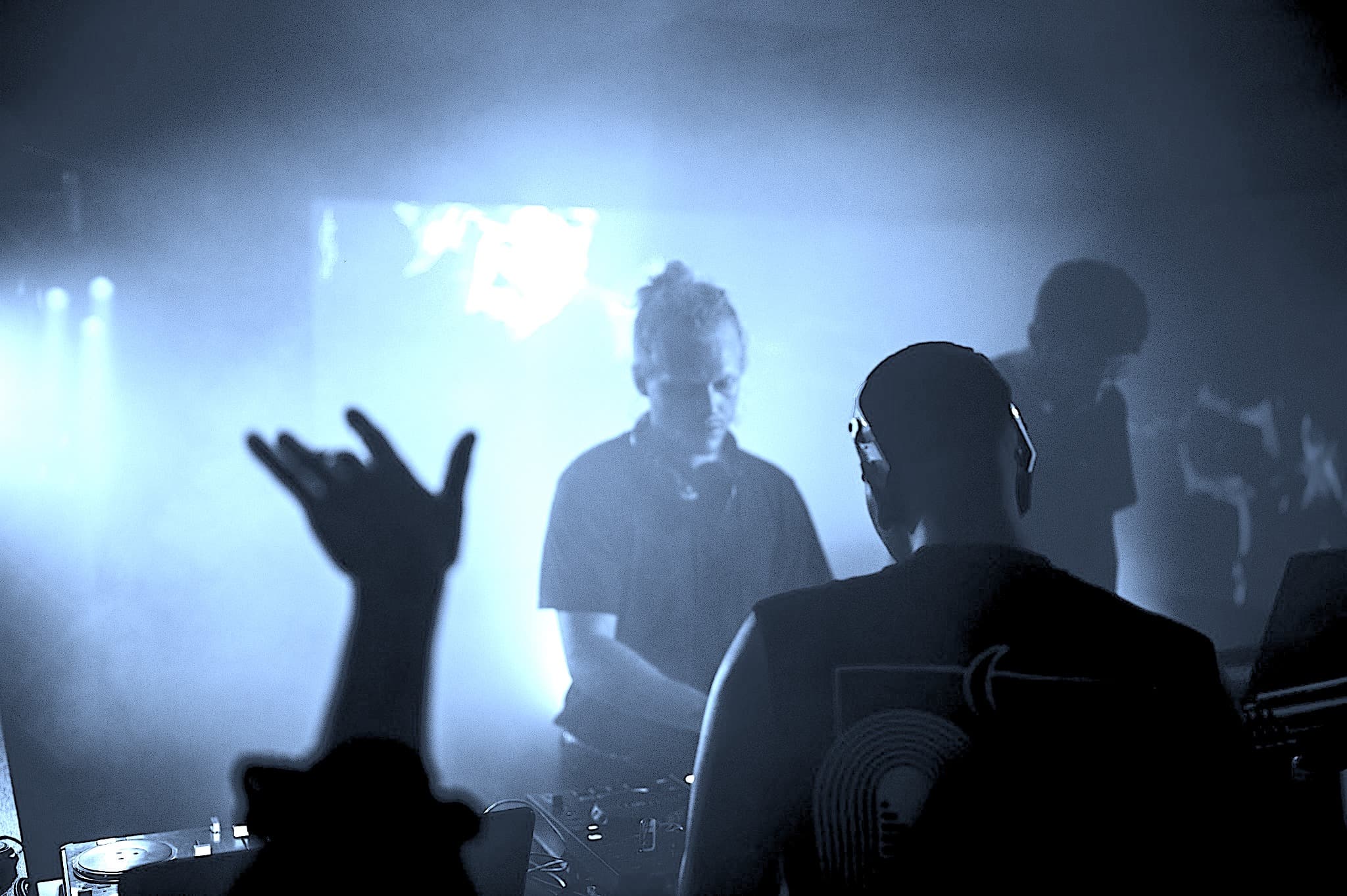 Crowd silhouetted under blue light at a Wellington club DJ set